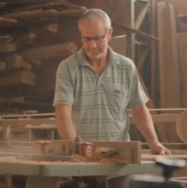 Homem marceneiro cortando madeira