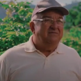  Homem agricultor de camisa branca e boné na frente de uma plantação 