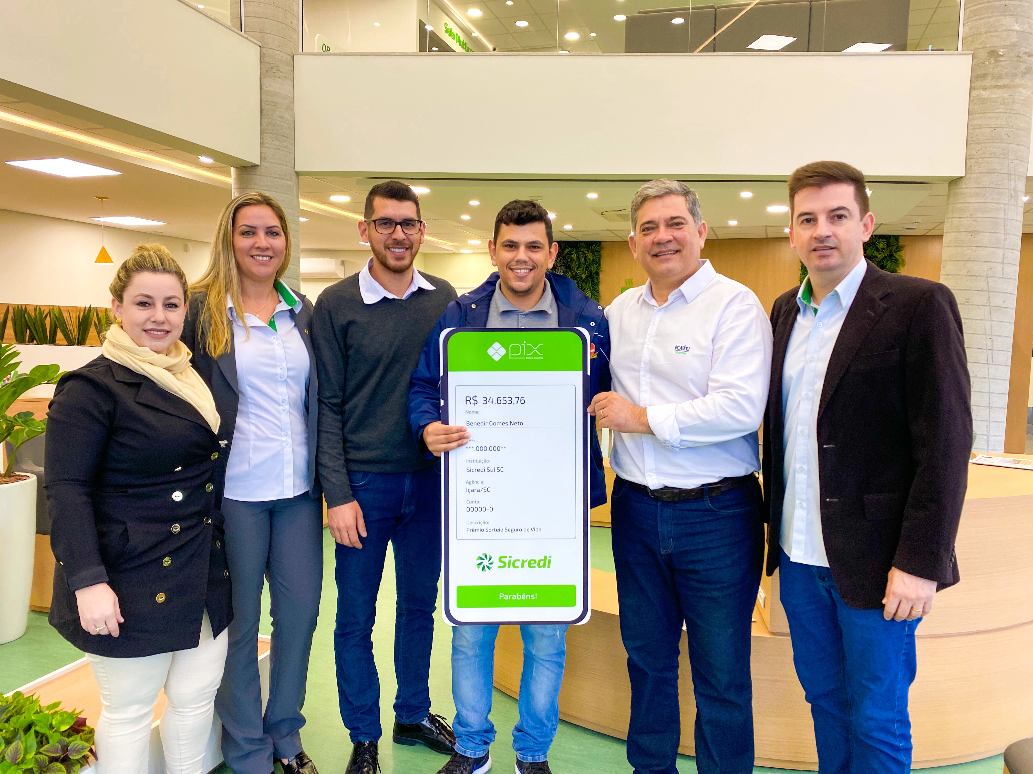  Associado ganhador com equipe da sede da cooperativa, gerentes e representante da Icatu Seguros 
