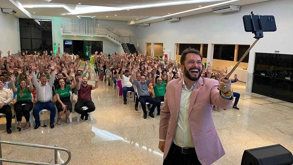  Palestrante Ricardo Gandra, segurando um celular e tirando foto com os associados 