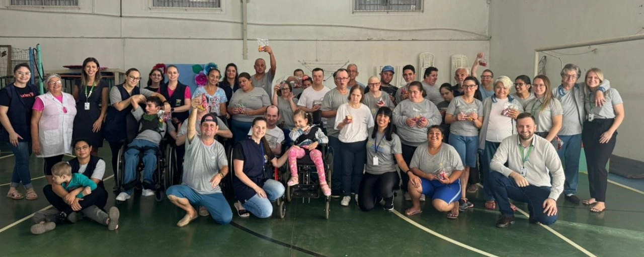  Grupo de pessoas reunidas junto a brindes. 