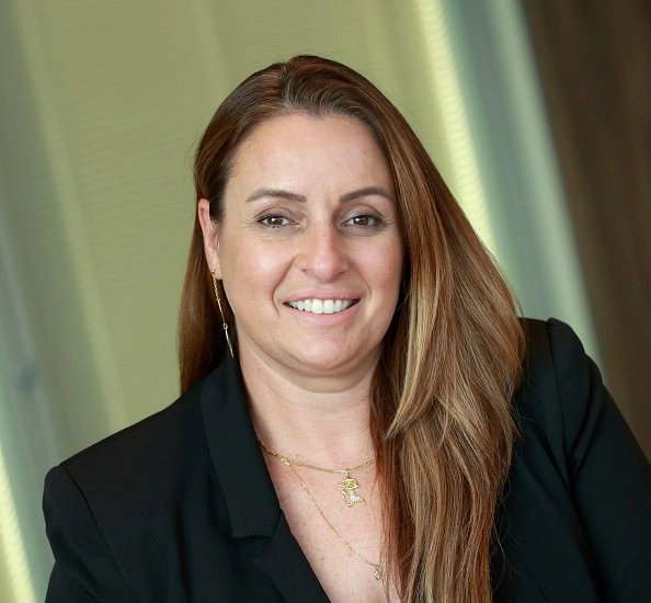 Mulher sorrindo, usando um blazer preto