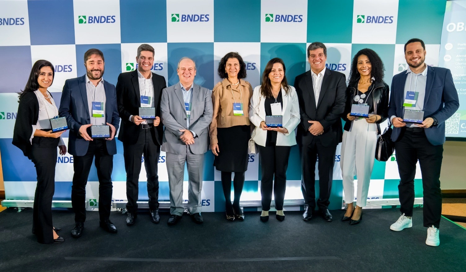  Pessoas com roupas formais recebendo premiação 
