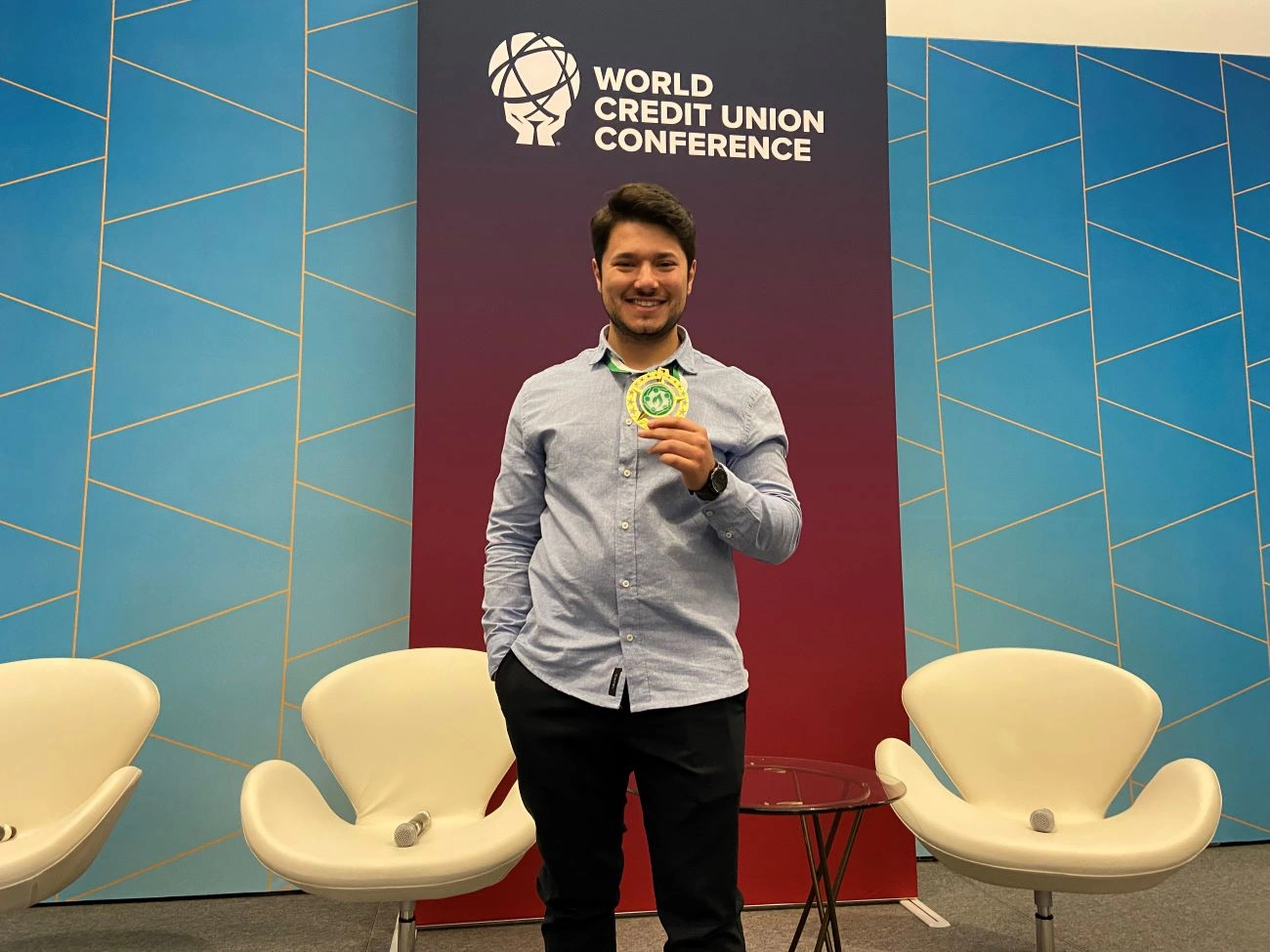 Homem de roupa formal segurando troféu