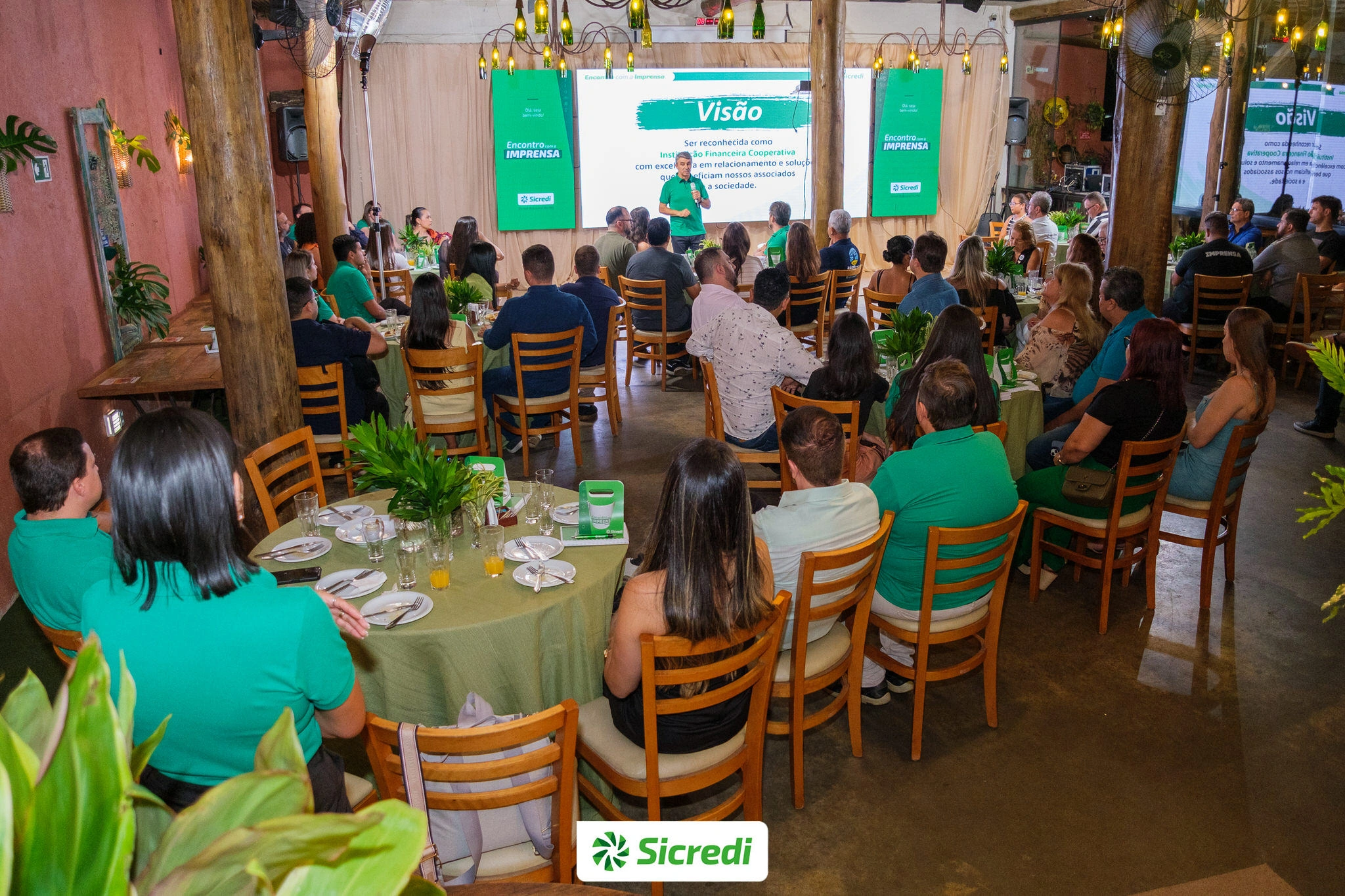  Imagem mostra mais de 60 jornalistas assistindo a uma palestra do Presidente da Sicredi Botucaraí RS/MG 