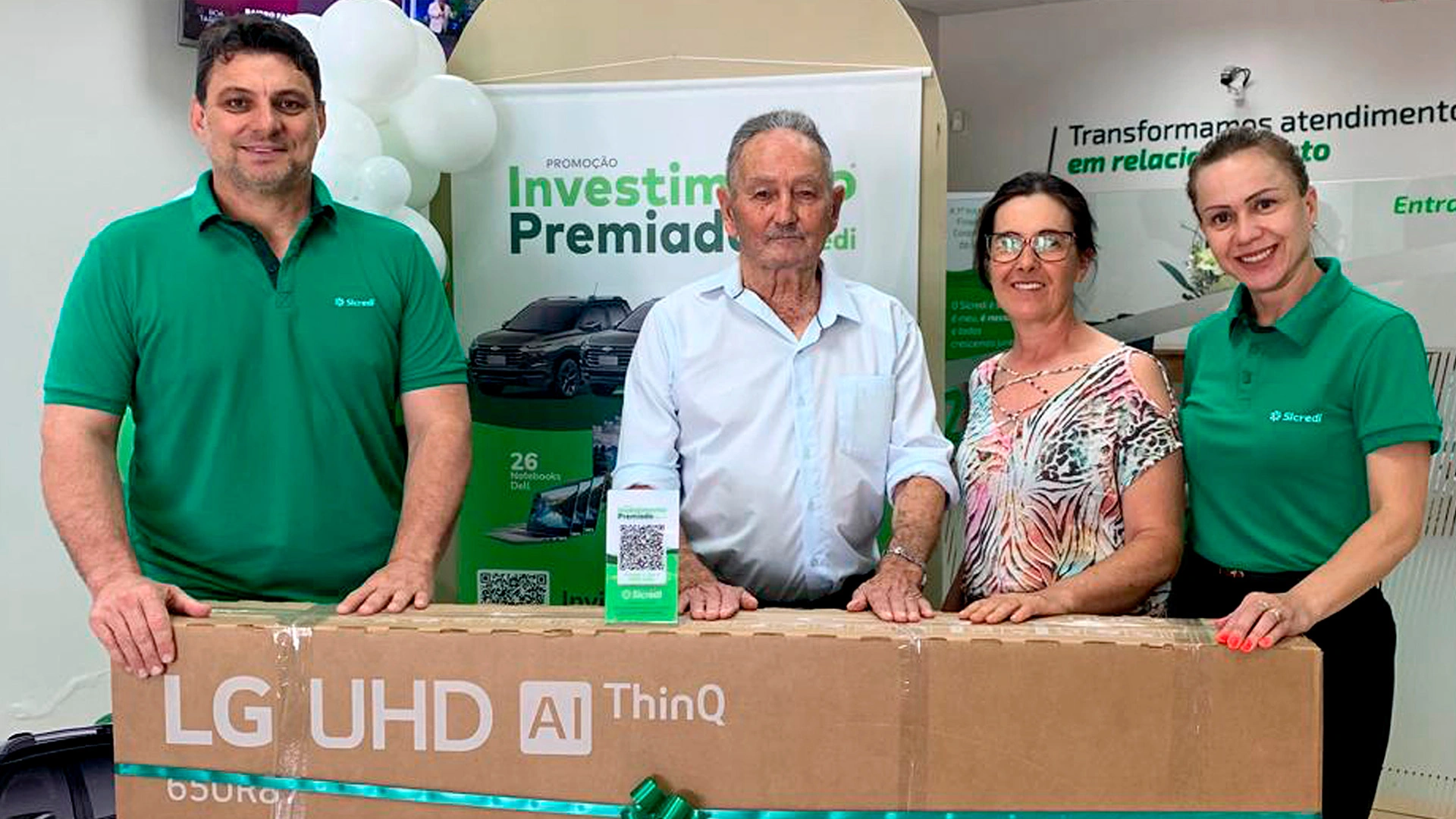  Colaboradores e associado ganhador em frente a Smart TV 