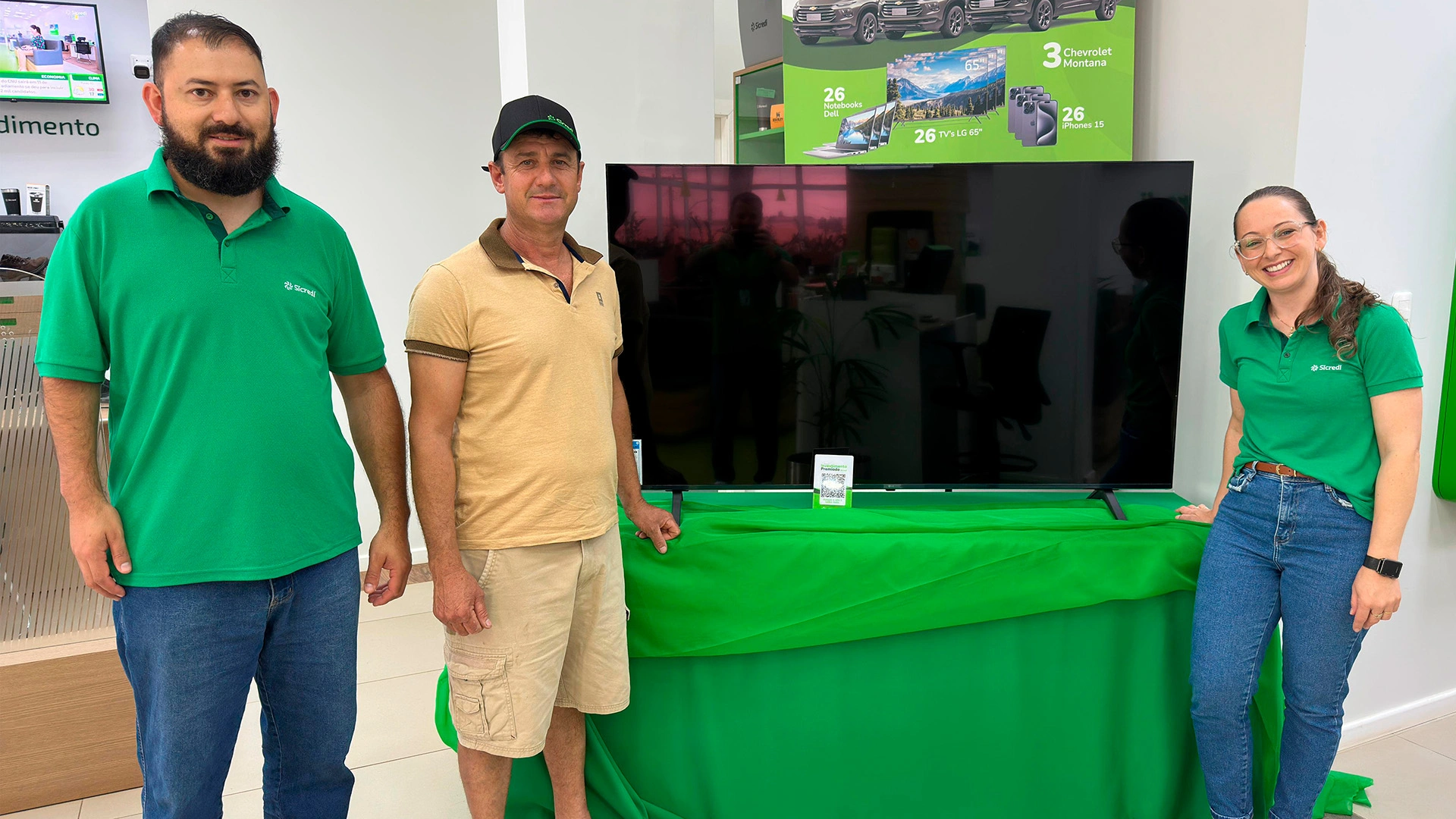  Colaboradores e associado ganhador em frente a Smart TV 