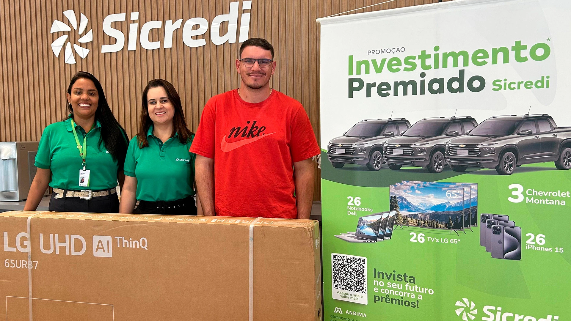  Colaboradores e associado ganhador em frente a Smart TV 