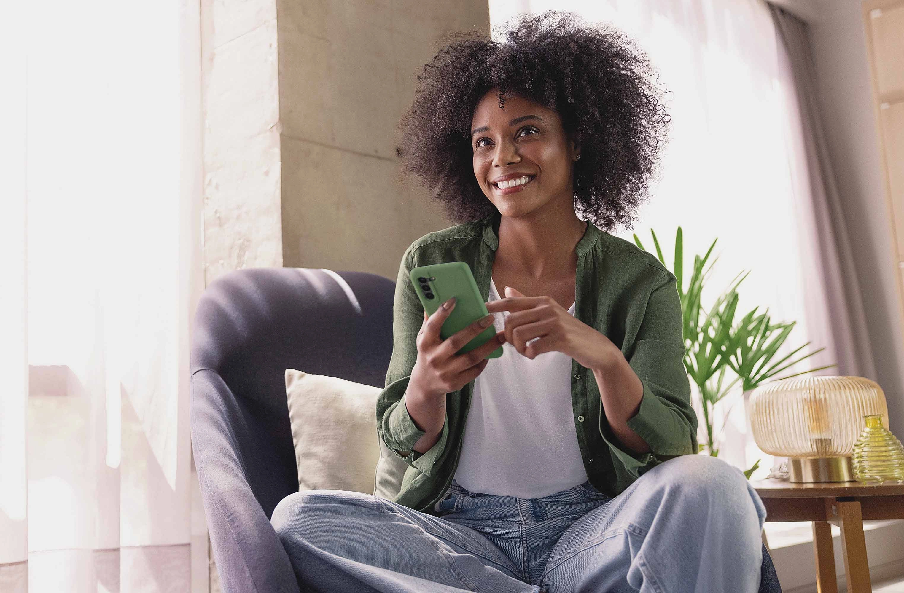  Associada sorrindo e utilizando seu smartphone 