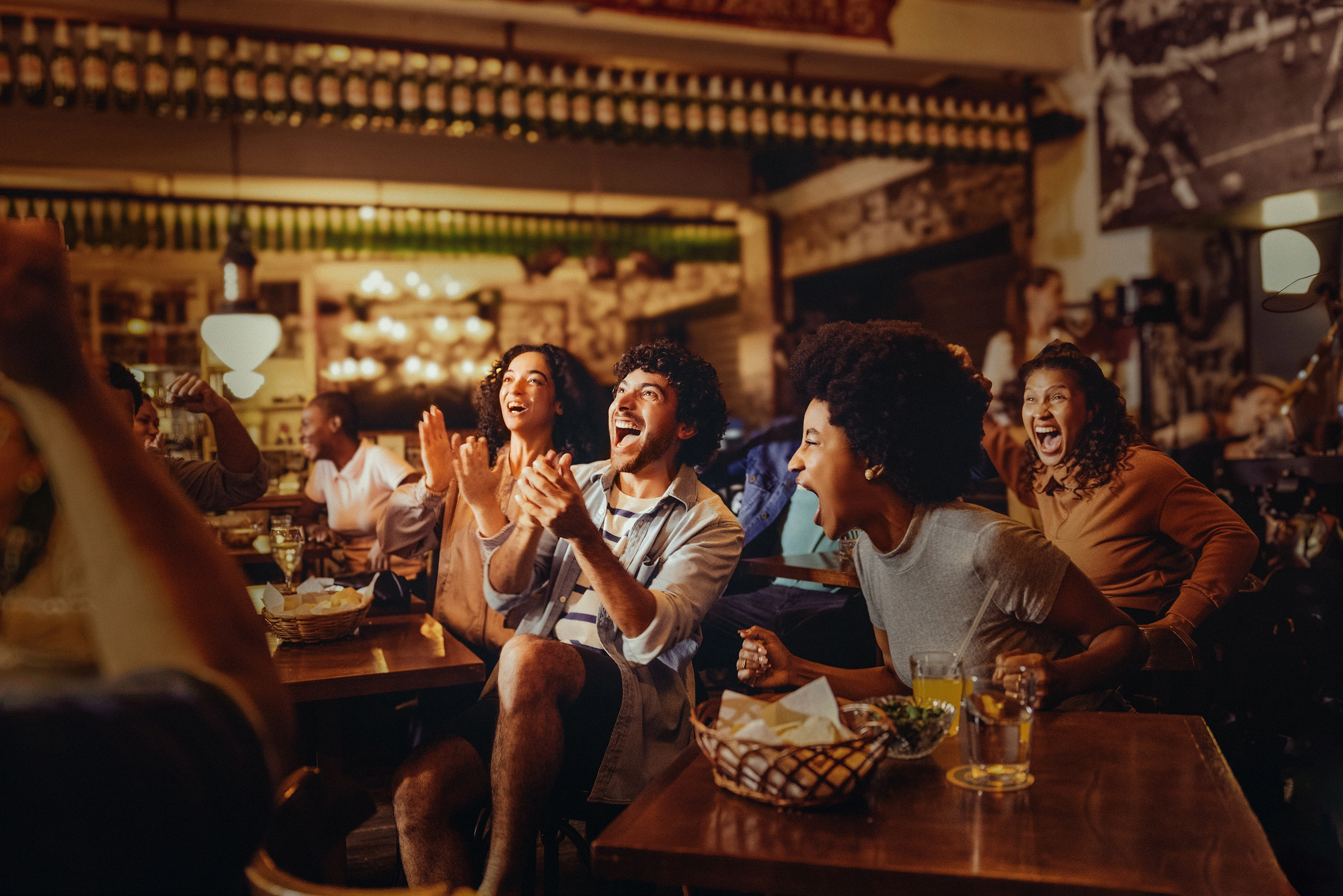  Torcedores vibrando assistindo ao jogo de futebol em um bar 