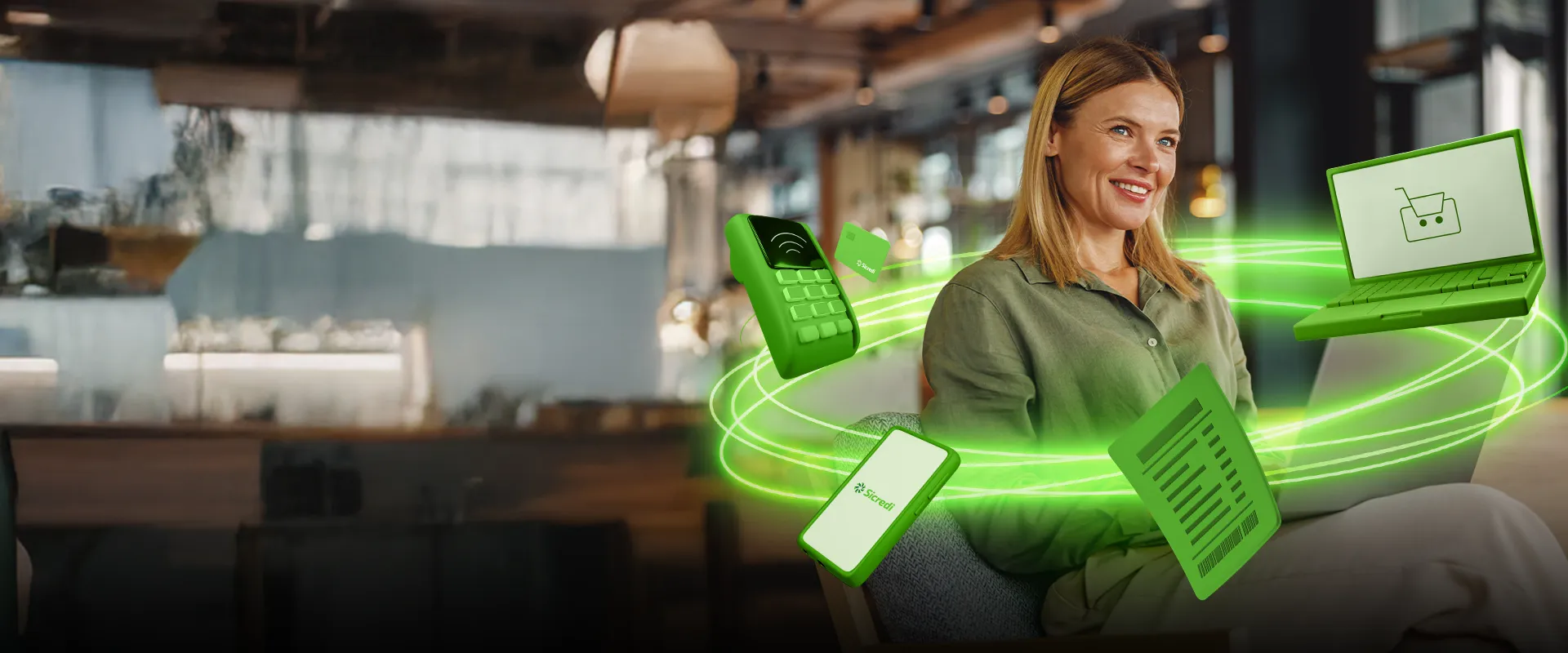  mulher empresária sentada em uma cadeira mexendo no notebook, ela veste uma camisa verde e tem cabelos loiros. 