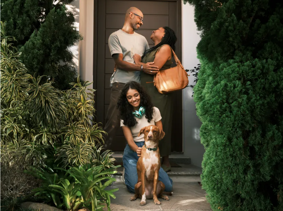  Casal com cachorro sentados na mala de um carro, simbolizando viagem. 