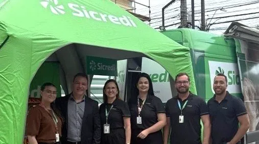Colaboradores em frente à tenda e agência móvel