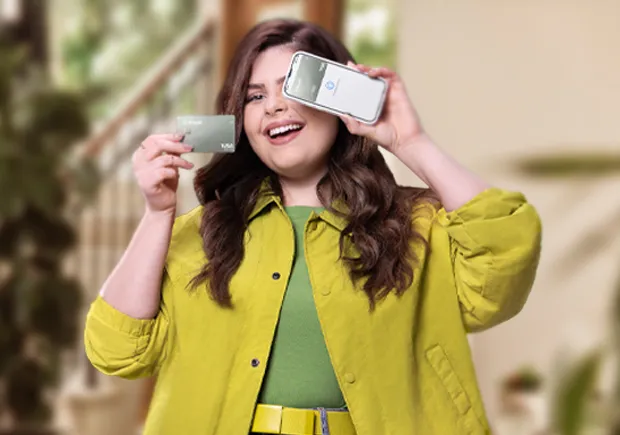  Mulher segurando o cartão Sicredi. 