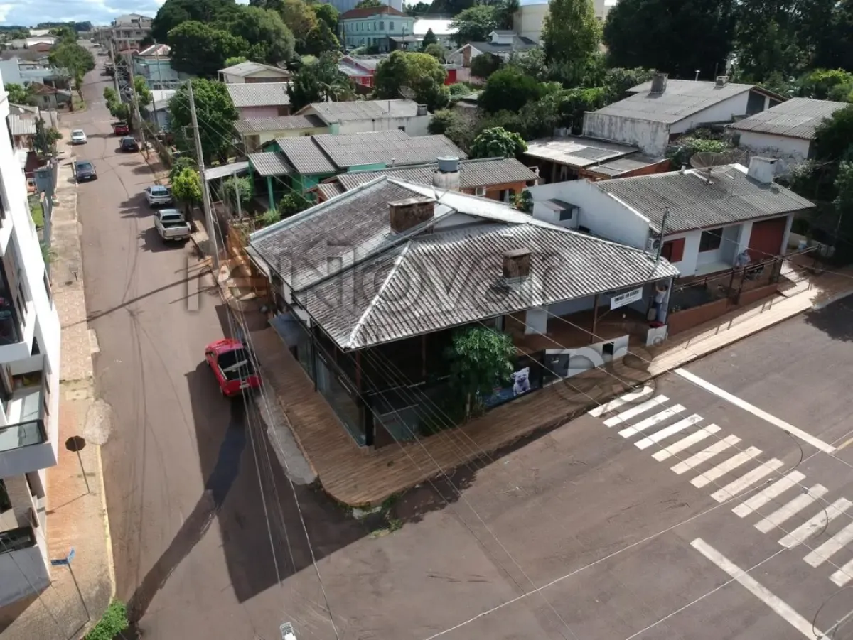  Imagem aérea de imóvel residencial de esquina localizado em Ibirubá (RS), com construção térrea, cobertura em telhas onduladas, cercado por muros, inserido em área urbana com vias asfaltadas e edificações no entorno. 