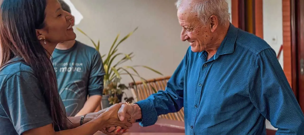  Atendimento do Sicredi com aperto de mãos entre colaborador e associado, em ambiente residencial. Imagem representa proximidade, relacionamento cooperativo e soluções financeiras do Sicredi voltadas ao cuidado com pessoas e comunidades. 