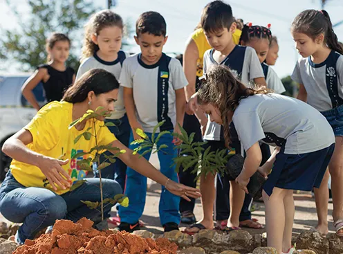  crianças com professora brincando educação financeira 
