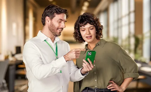  colaborador ajudando uma associada no celular, presencialmente. 