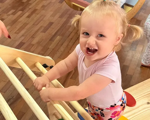  bebe brincando subindo uma escada em projeto social 
