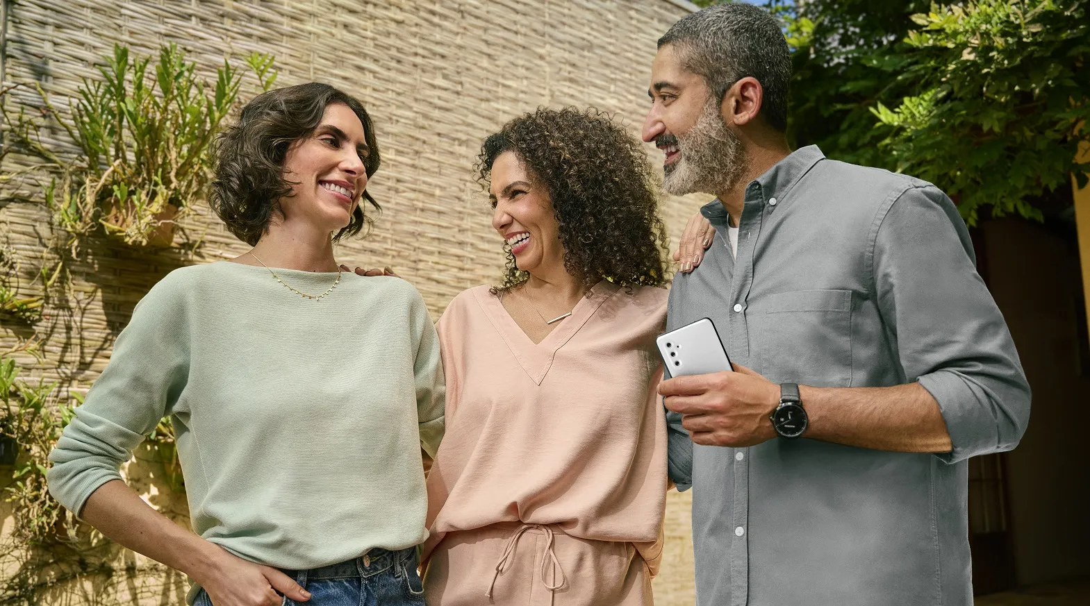  3 amisgos sorrindo e abraçados 