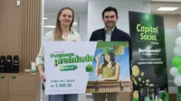 Presidente Fernando Fenner realiza a entrega oficial do prêmio da campanha Poupança Premiada à associada Juliana em agência da Sicredi Aliança.