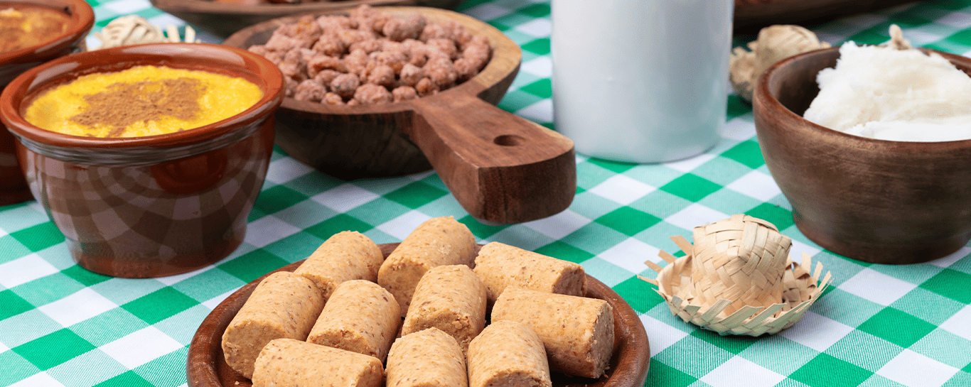  mesa com toalha quadriculada com quitutes de festa junina 