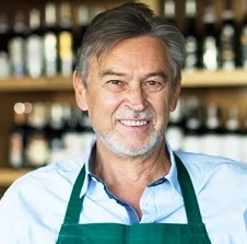  Vendedor de vinhos importados segurando uma caixa em sua loja 