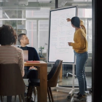  Uma mulher fazendo uma apresentação para seus colegas - seguro acidentes pessoais e coletivos curto prazo Sicredi 