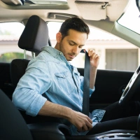  Homem colocando o cinto de segurança do carro - Seguro Auto Sicredi 