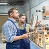  Dois funcionários observando uma máquina dentro de uma empresa - Seguro maquinas e equipamentos Sicredi 