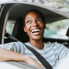  Mulher feliz no carro com a cobertura do seguro auto Sicredi 