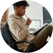  Homem sentado em cadeira lendo um livro em cima dos joelhos 