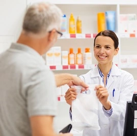 Homem sendo atendido por farmacêutica na farmácia