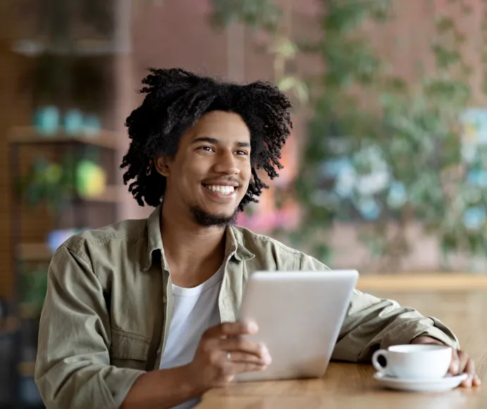  Associado do Sicredi sorrindo com um tablet na mão 