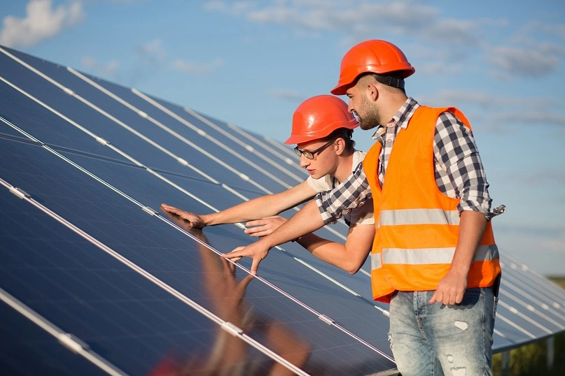 Técnicos fazendo a instalação de placas solares com financiamento de energia solar Sicredi.