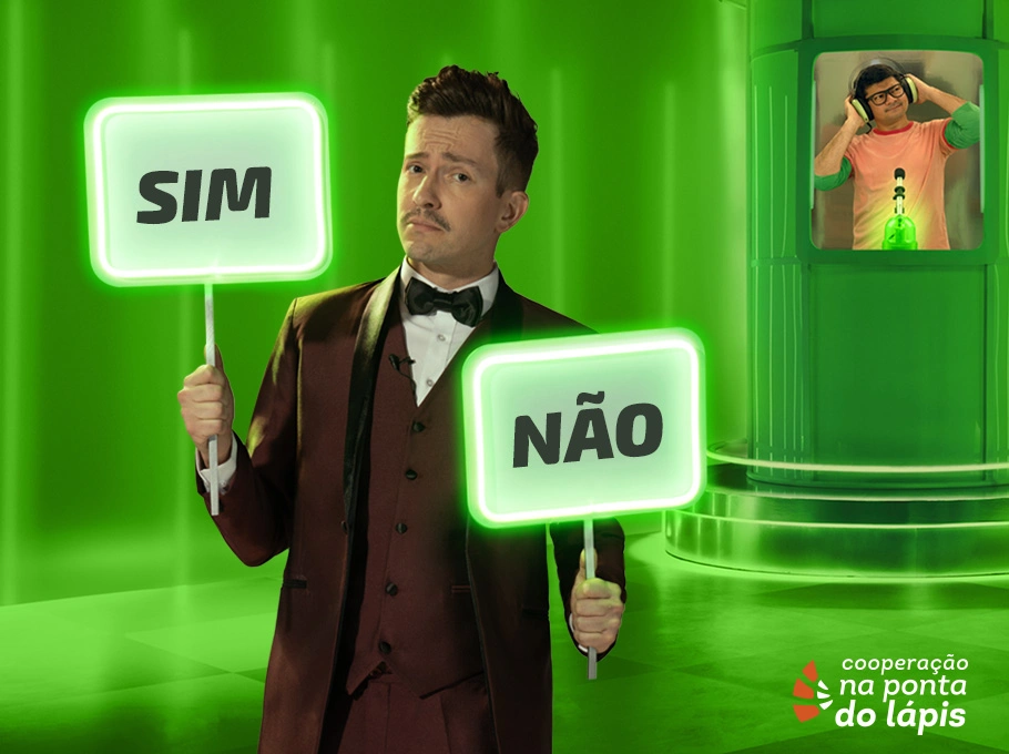  Imagem com fundo verde e no primeiro plano um homem segura duas placas, na mão direita "sim" e na direita "não", e em segundo plano um homem dentro de uma cabine usando fones de ouvido 