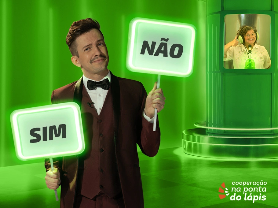  Imagem com fundo verde e no primeiro plano um homem segura duas placas, na mão direita "sim" e na direita "não", e em segundo plano uma mulher dentro de uma cabine usando fones de ouvido 