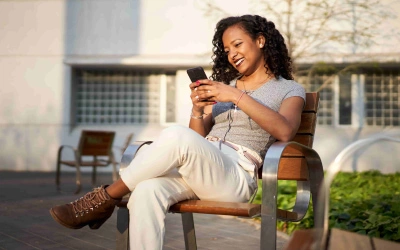 Associada do Sicredi feliz usando o aplicativo no celular