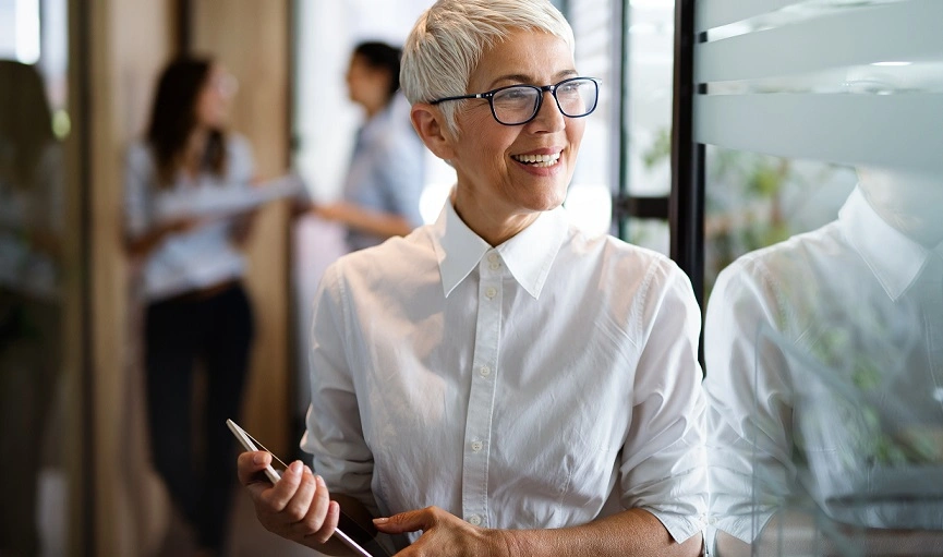  mulher de cabelos claros e curtos, vestindo camisa branca e sorrindo 