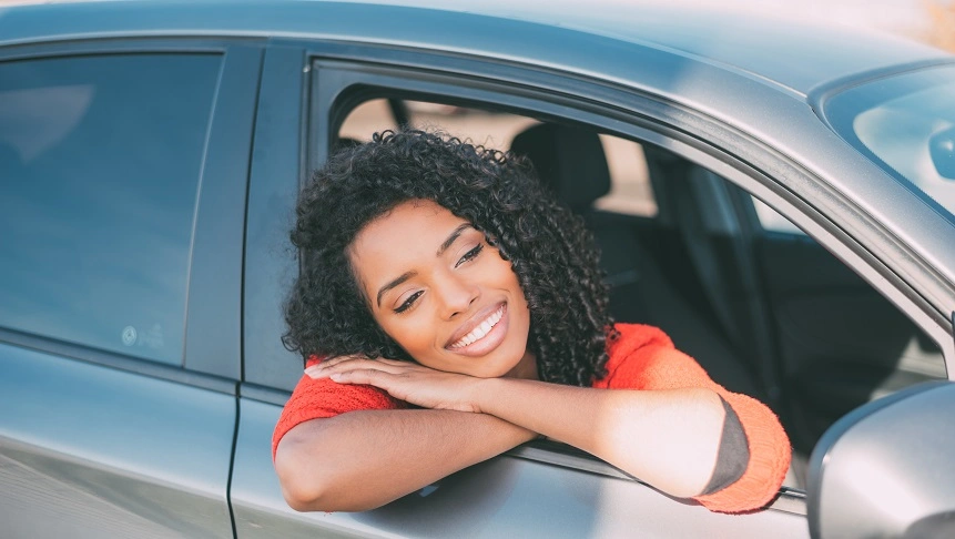  Mulher abraçada em seu carro novo após fazer um financiamento de veículo pelo Sicredi 