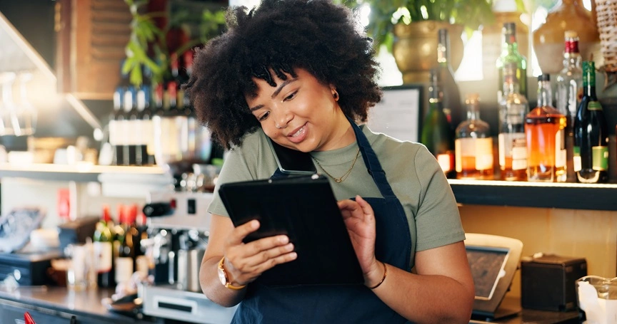  Mulher negra contratando o Seguro Empresarial do Sicredi em seu bar. 
