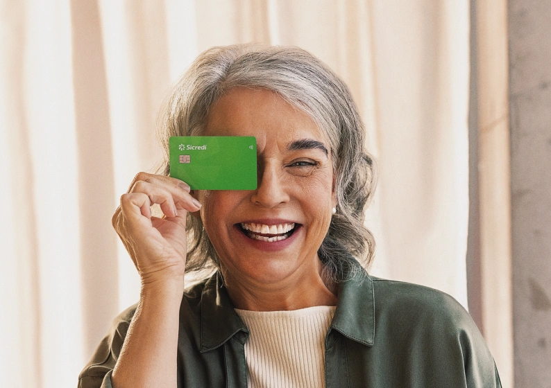  MULHER SORRINDO COM CARTÃO NA MÃO 