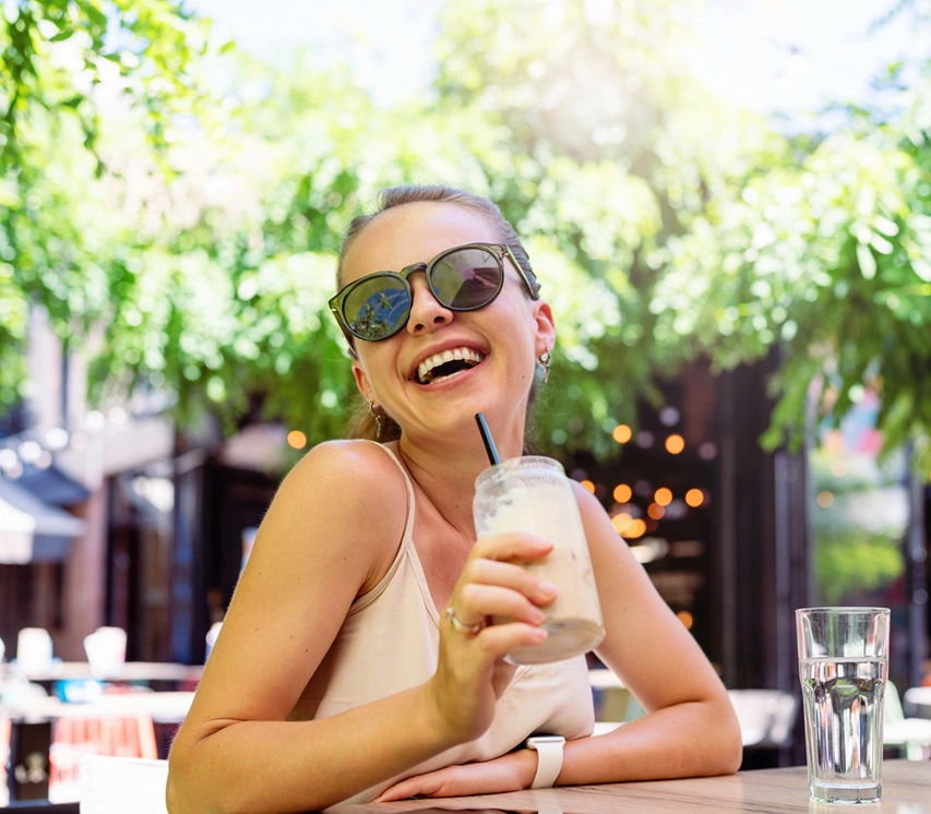  Mulher feliz no aeroporto com programa de recompensa do Sicredi. 