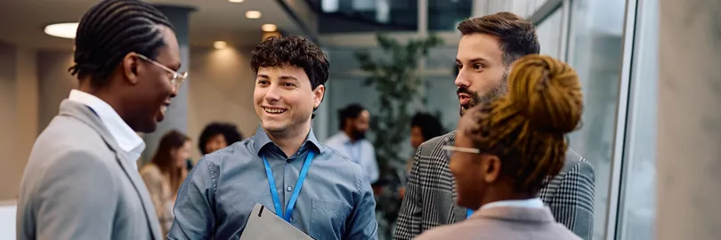 quatro colegas de trabalho sorridentes em conversa descontraída