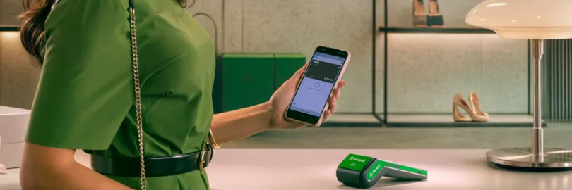  mulher com vestido verde paga conta por aproximação com celular 