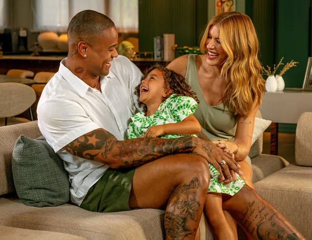 Leo Santana, Lore Improta e filha brincam no sofá de casa