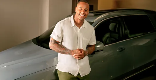 Leo Santana, Lore Improta e filha sorriem no sofá de casa