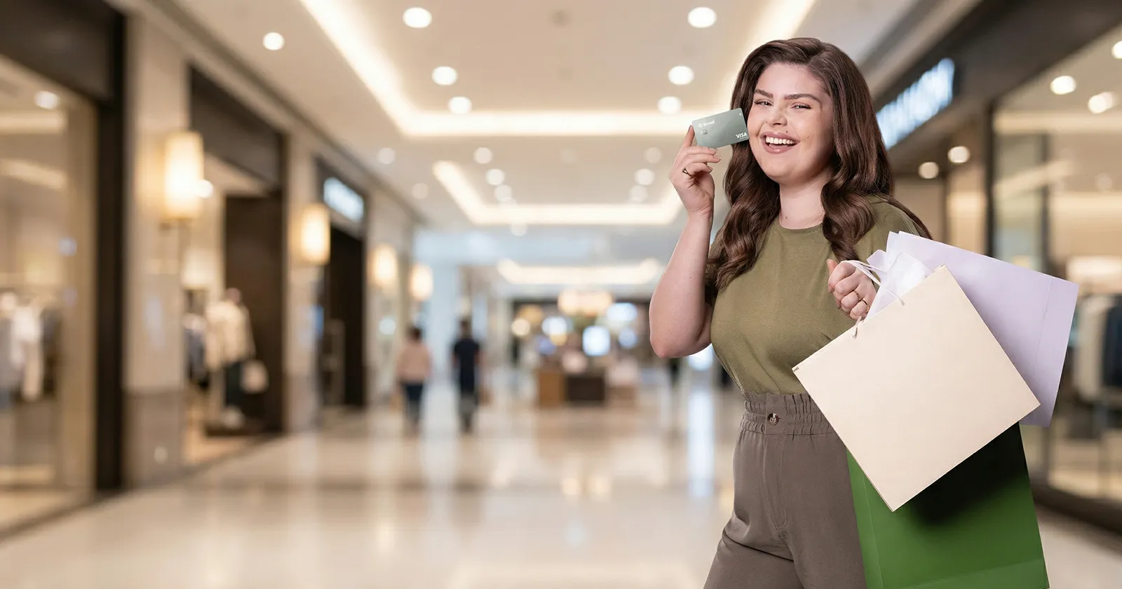  mulher branca sorri segurando celular em shopping 