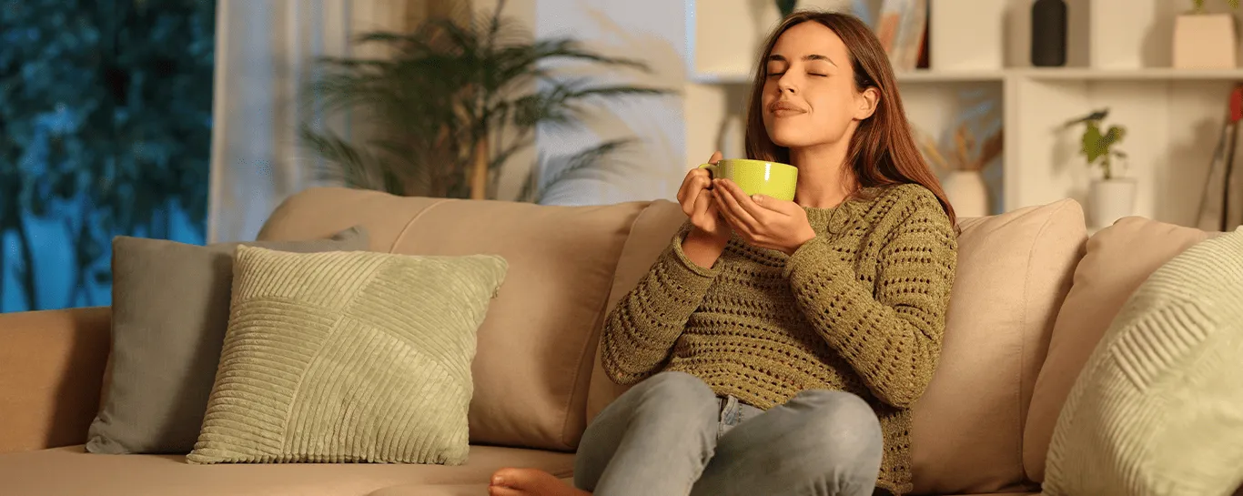  mulher sentada no sofá com uma caneca na mão 
