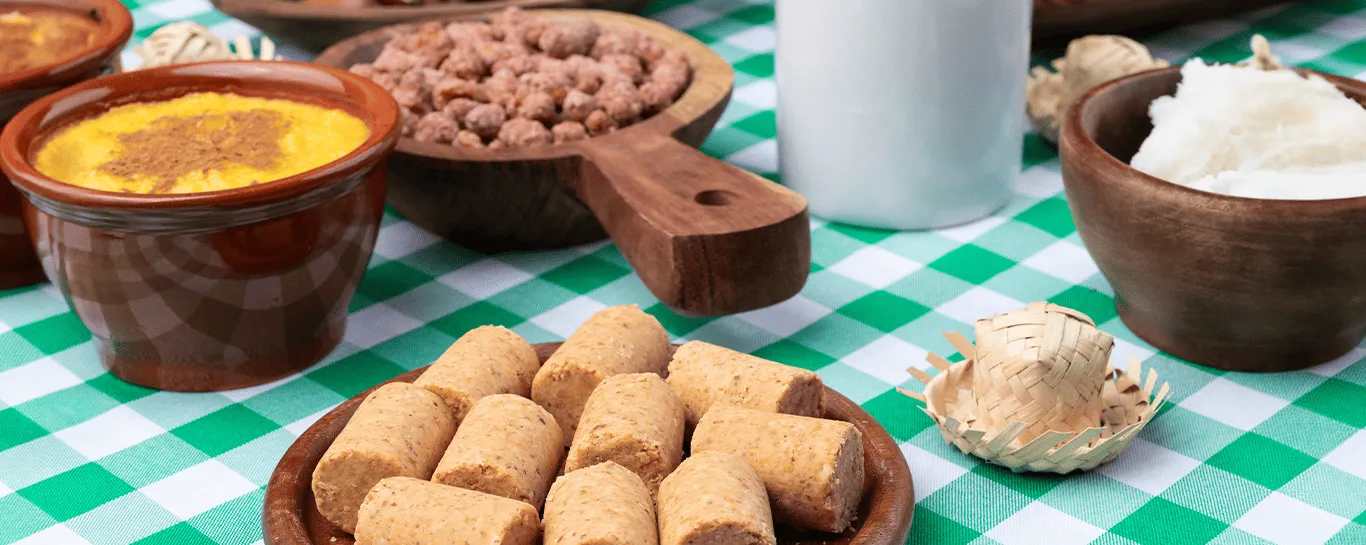  mesa com toalha quadriculada com quitutes de festa junina 